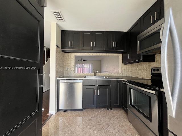 kitchen with tasteful backsplash, ceiling fan, sink, and stainless steel appliances