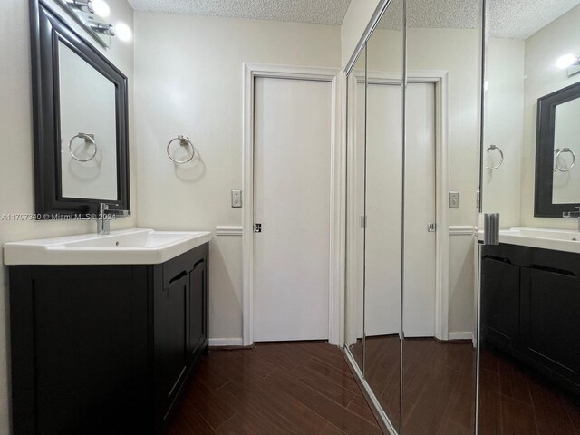 bathroom featuring hardwood / wood-style floors, vanity, and a textured ceiling