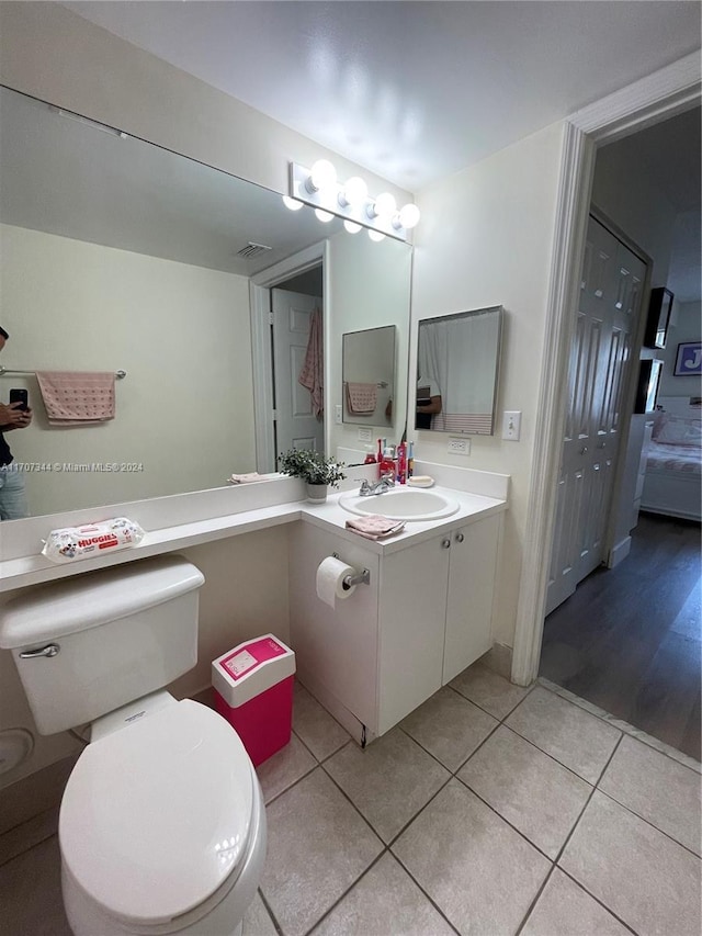 bathroom featuring tile patterned flooring, vanity, and toilet