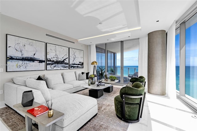 living room featuring expansive windows, a water view, and plenty of natural light