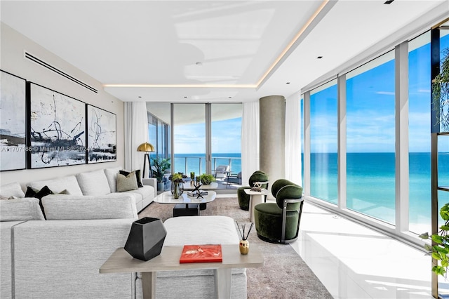 living room featuring a water view and a wall of windows