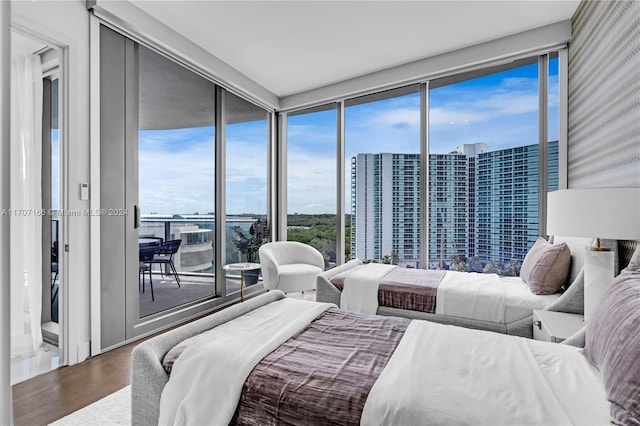 bedroom with hardwood / wood-style flooring and expansive windows