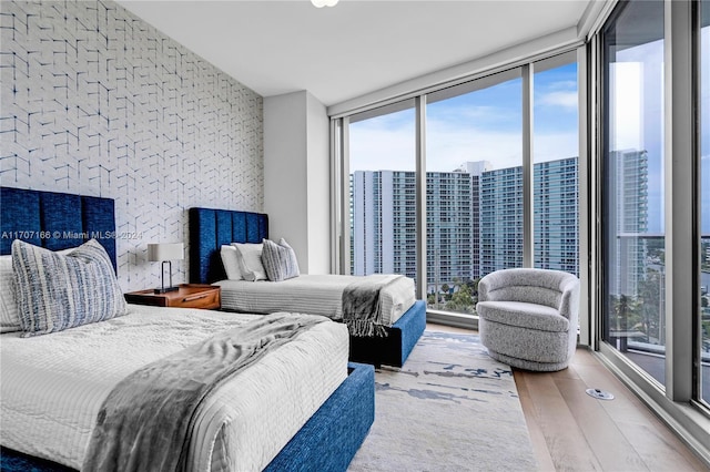 bedroom featuring multiple windows, hardwood / wood-style floors, and expansive windows