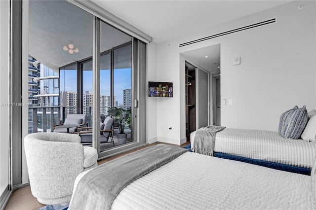 bedroom with access to outside, hardwood / wood-style flooring, and floor to ceiling windows