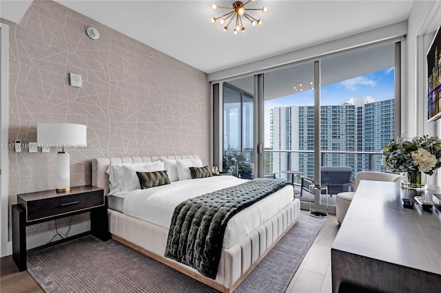 bedroom with tile patterned floors, multiple windows, tile walls, and an inviting chandelier