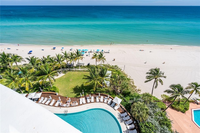 view of swimming pool featuring a water view and a beach view