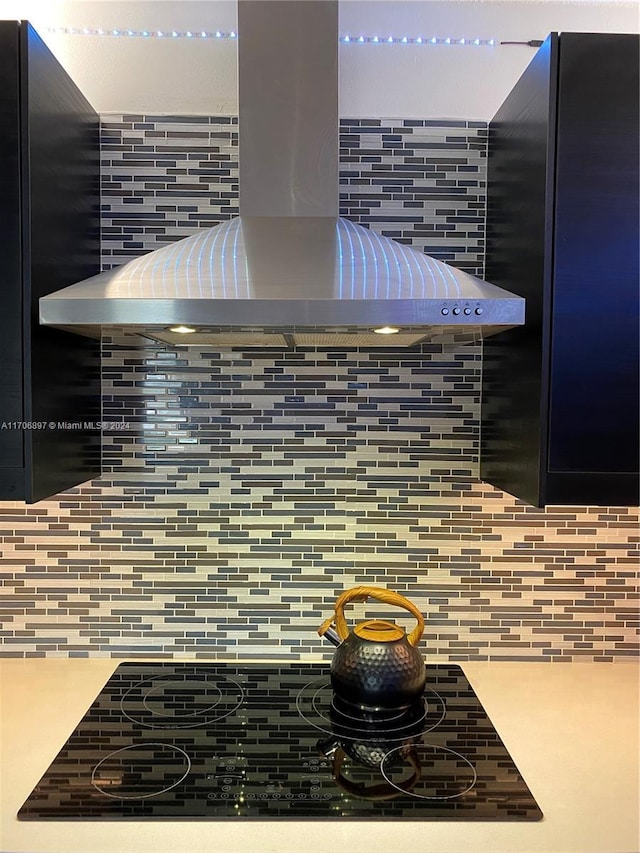 interior details with decorative backsplash and exhaust hood