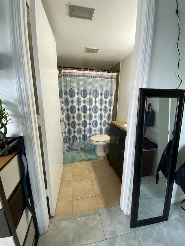 bathroom with toilet, vanity, tile patterned floors, and curtained shower