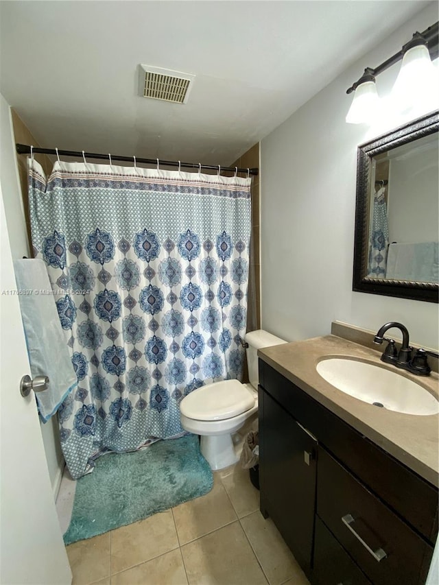 bathroom featuring tile patterned flooring, vanity, curtained shower, and toilet