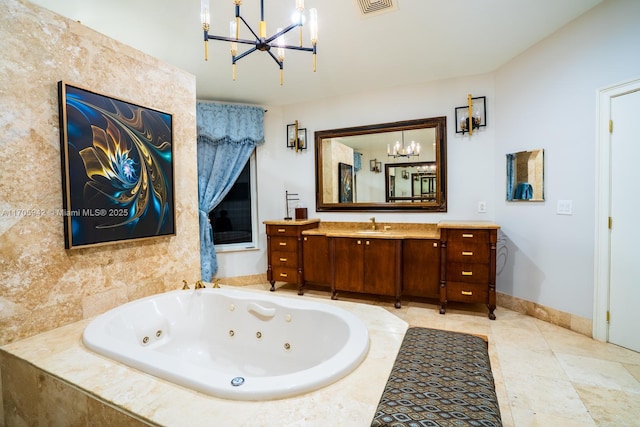 bathroom with an inviting chandelier, vanity, and tiled bath