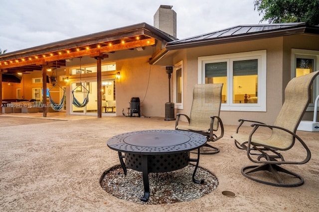 rear view of house featuring a patio and a fire pit