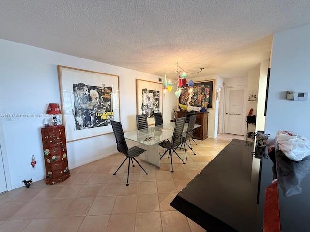 dining area with light tile patterned floors and a textured ceiling