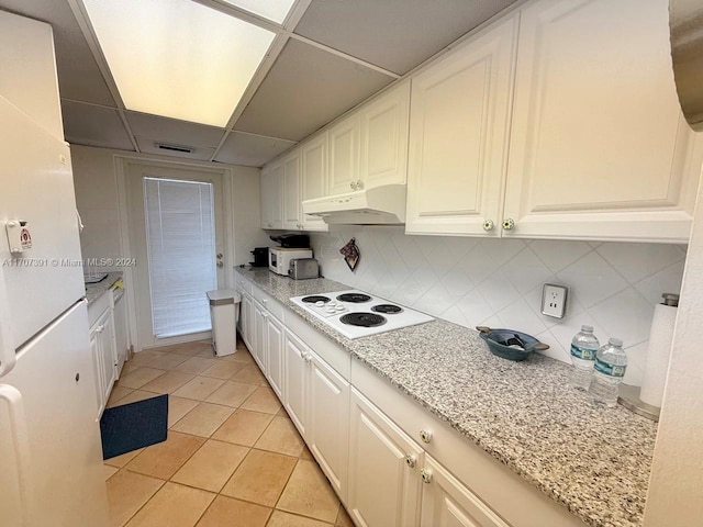 kitchen featuring white electric cooktop, light tile patterned floors, white cabinetry, and tasteful backsplash