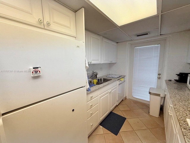 kitchen with white cabinetry, white appliances, sink, and light tile patterned floors