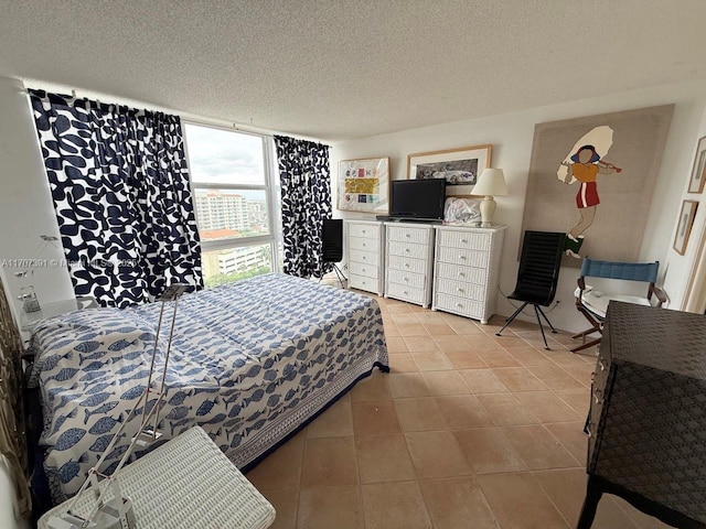 tiled bedroom with a wall of windows and a textured ceiling