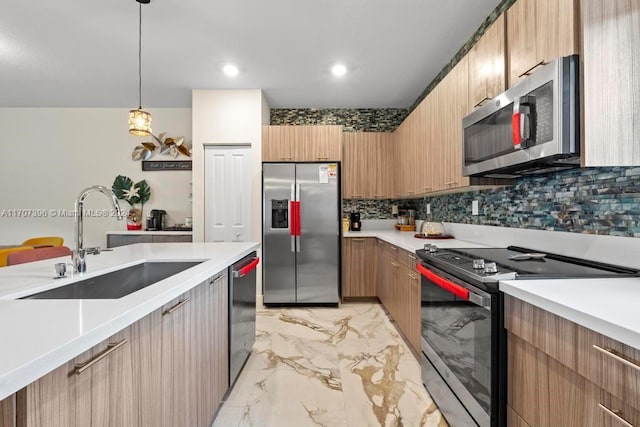 kitchen with decorative backsplash, sink, stainless steel appliances, and decorative light fixtures