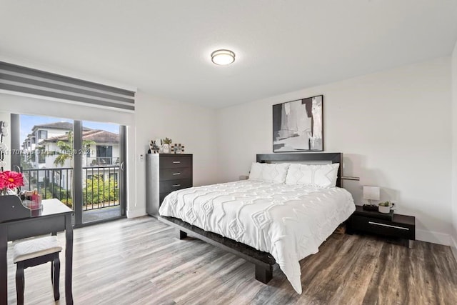 bedroom featuring wood-type flooring and access to outside