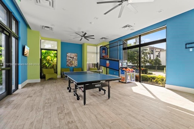 recreation room with ceiling fan, light hardwood / wood-style floors, and a healthy amount of sunlight