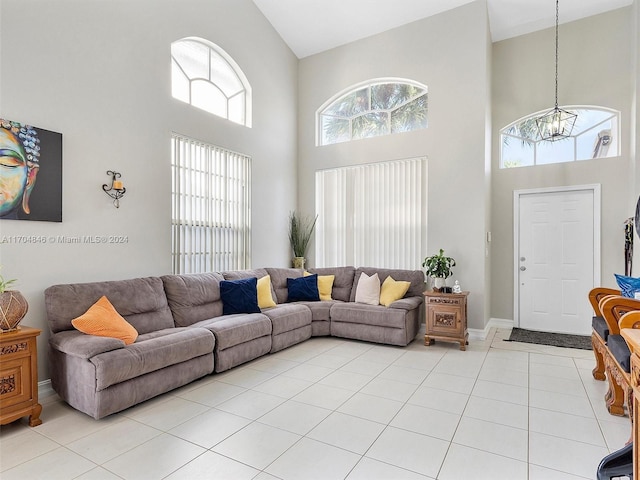 tiled living room featuring a high ceiling and an inviting chandelier