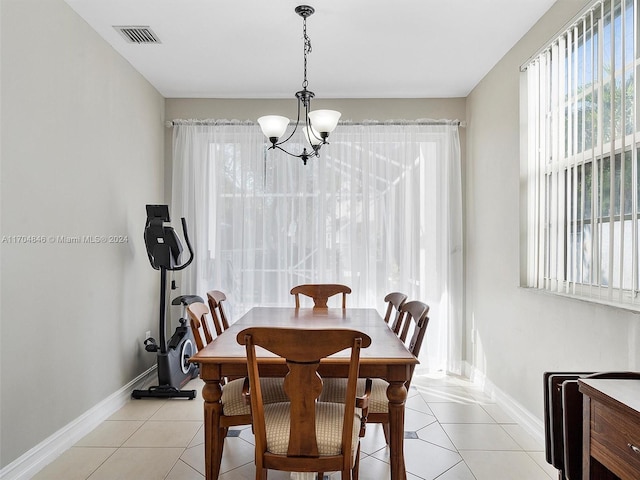 tiled dining room featuring an inviting chandelier