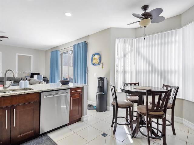 kitchen with light stone counters, stainless steel dishwasher, ceiling fan, and sink