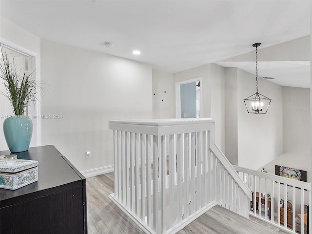 hall featuring a chandelier and light hardwood / wood-style flooring