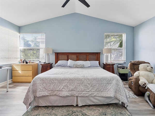 bedroom with ceiling fan, light wood-type flooring, and lofted ceiling