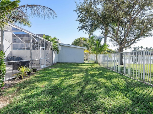 view of yard featuring a lanai and a water view