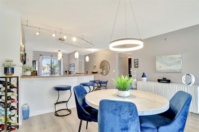 dining area featuring light hardwood / wood-style floors and a textured ceiling