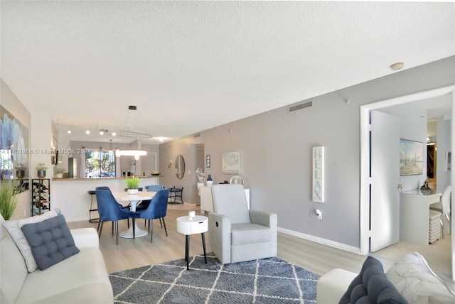 living room with wood-type flooring and a textured ceiling