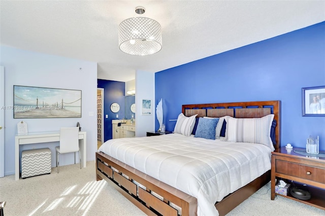 carpeted bedroom with a textured ceiling and ensuite bath