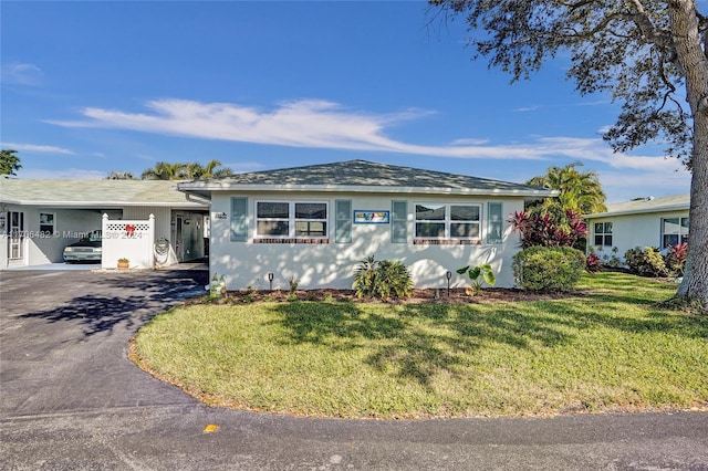 ranch-style house with a front yard and a carport