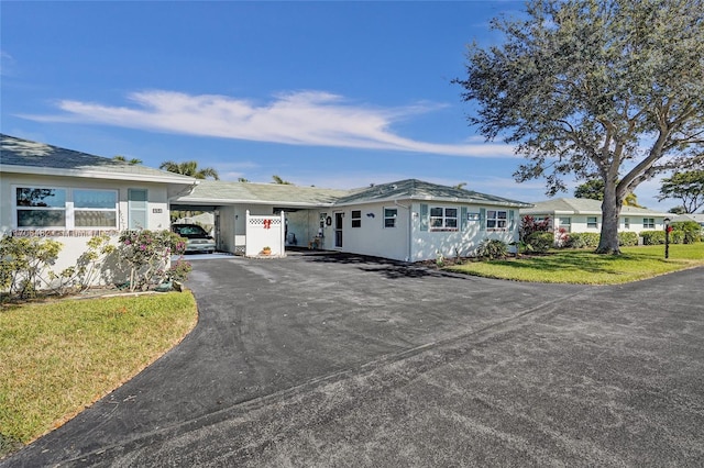 ranch-style home with a front yard and a carport