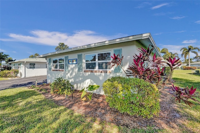 view of side of home with a yard