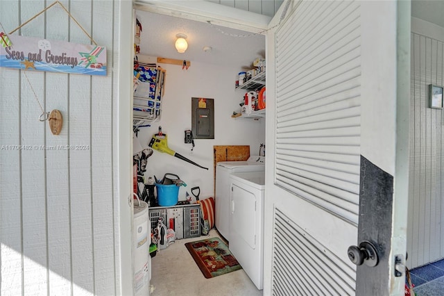 laundry area with electric panel, washer and clothes dryer, and a textured ceiling