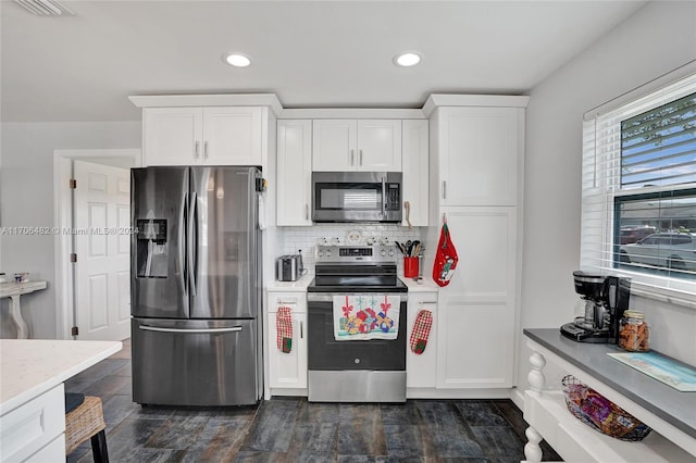 kitchen with tasteful backsplash, white cabinetry, and appliances with stainless steel finishes