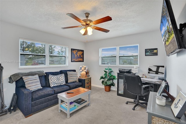 office space with ceiling fan, light colored carpet, and a textured ceiling