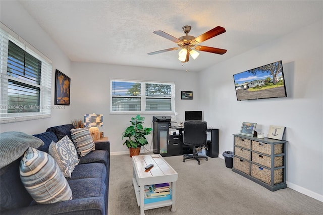 carpeted office space featuring ceiling fan