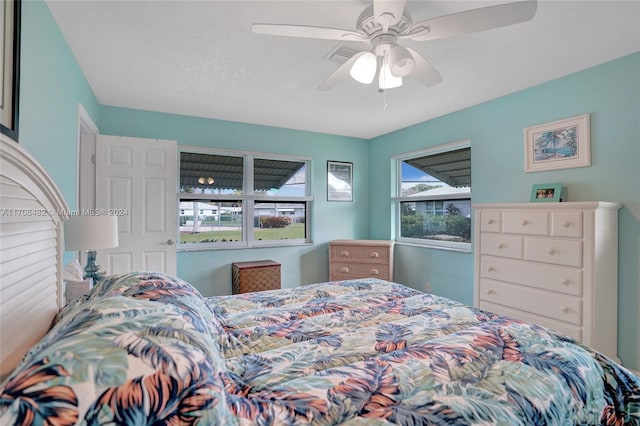 bedroom with ceiling fan and a textured ceiling