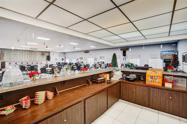 interior space featuring butcher block countertops, dark brown cabinetry, and light tile patterned floors