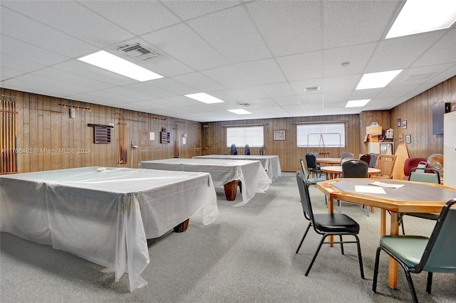 playroom with light carpet, a paneled ceiling, wooden walls, and pool table