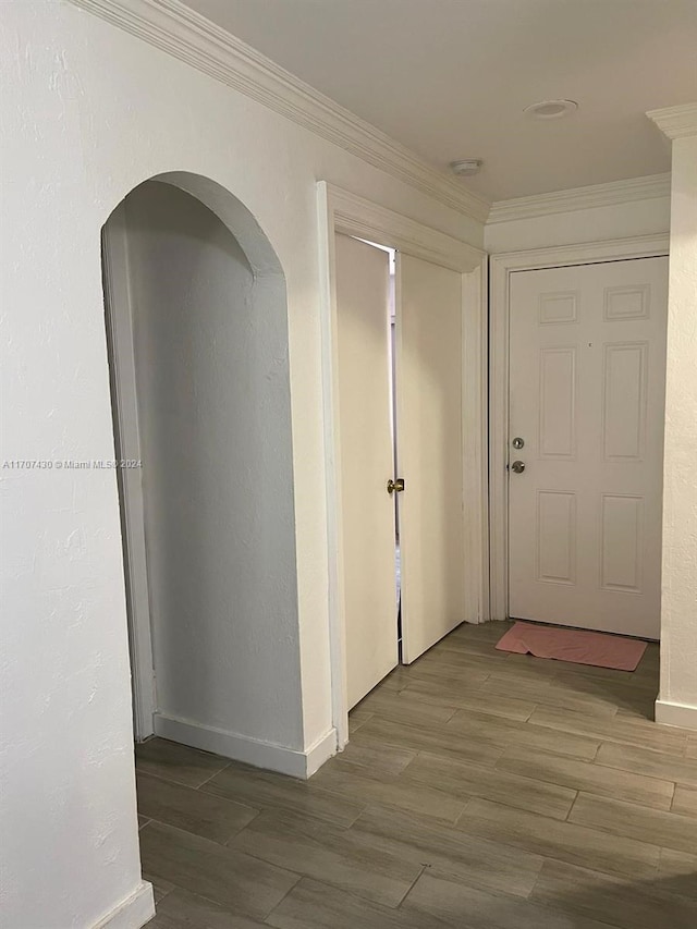 corridor with hardwood / wood-style floors and ornamental molding