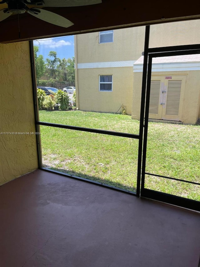 unfurnished sunroom with ceiling fan