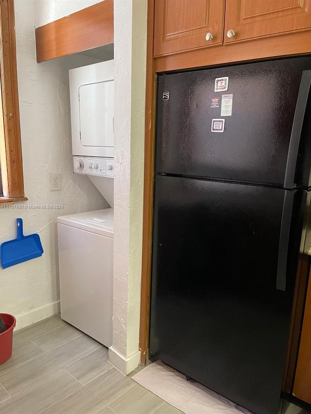 washroom featuring light wood-type flooring and stacked washer and clothes dryer