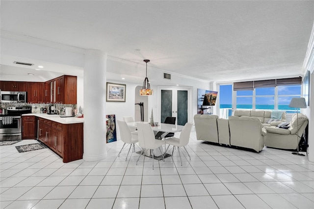 interior space featuring pendant lighting, crown molding, tasteful backsplash, a wall of windows, and stainless steel appliances