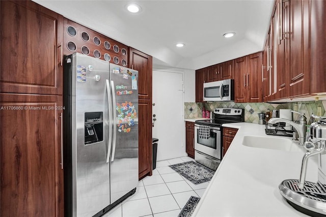 kitchen with backsplash, light tile patterned flooring, sink, and appliances with stainless steel finishes