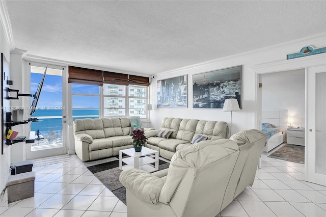 living room with a textured ceiling, a water view, plenty of natural light, and light tile patterned flooring