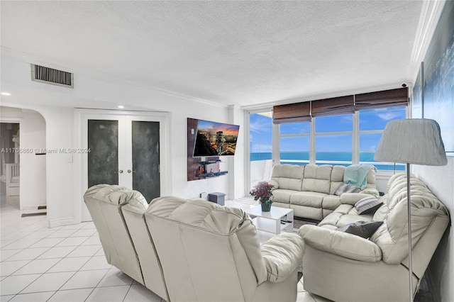 living room featuring a textured ceiling, ornamental molding, and light tile patterned flooring