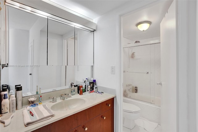 full bathroom with vanity, enclosed tub / shower combo, and toilet