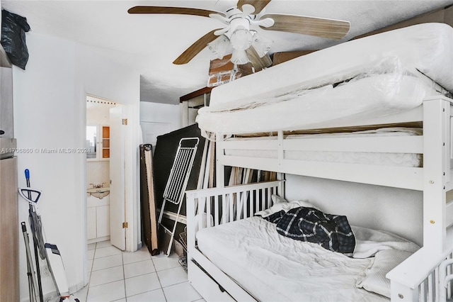 bedroom featuring ceiling fan, light tile patterned flooring, and a textured ceiling